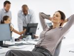 Female executive relaxing with hands behind head in office