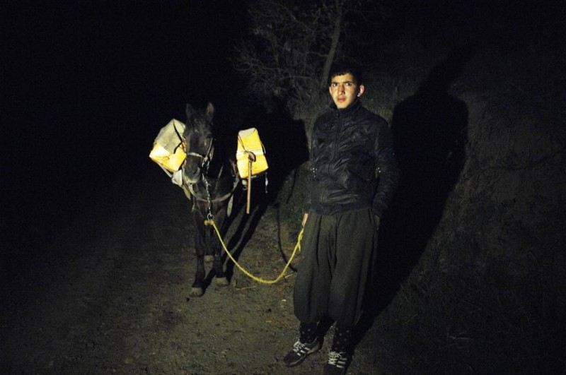 A smuggler holds the leash of a horse carrying alcoholic drinks during a smuggling operation to Iran at the border near Sulaimaniya, 260 km (162 miles) northeast of Baghdad March 20, 2010.    REUTERS/Jamal Penjweny