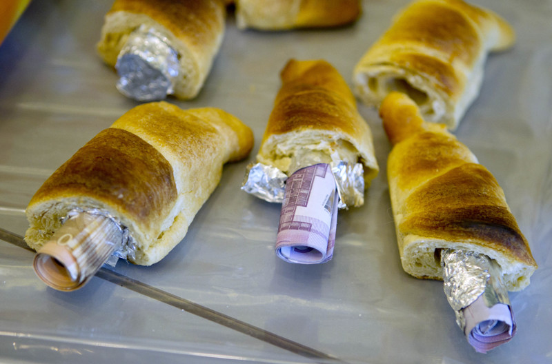 Money concealed in pastries that the German customs agency Zoll seized during an anti-money laundering operation, is displayed before the agency's annual statistics news conference at the finance ministry in Berlin March 16, 2012.   REUTERS/Thomas Peter (GERMANY - Tags: BUSINESS SOCIETY)