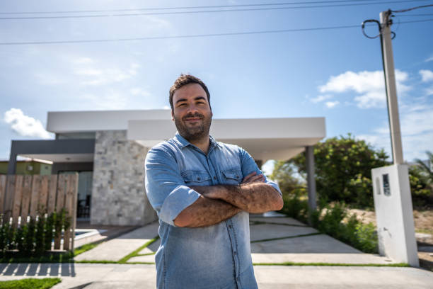 Portrait of a mid adult man in front his new house